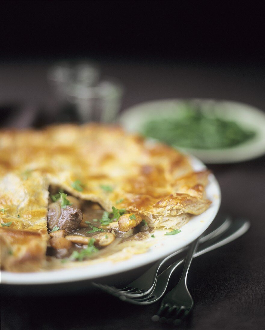 Beef pie with mushrooms and parsley, a piece cut