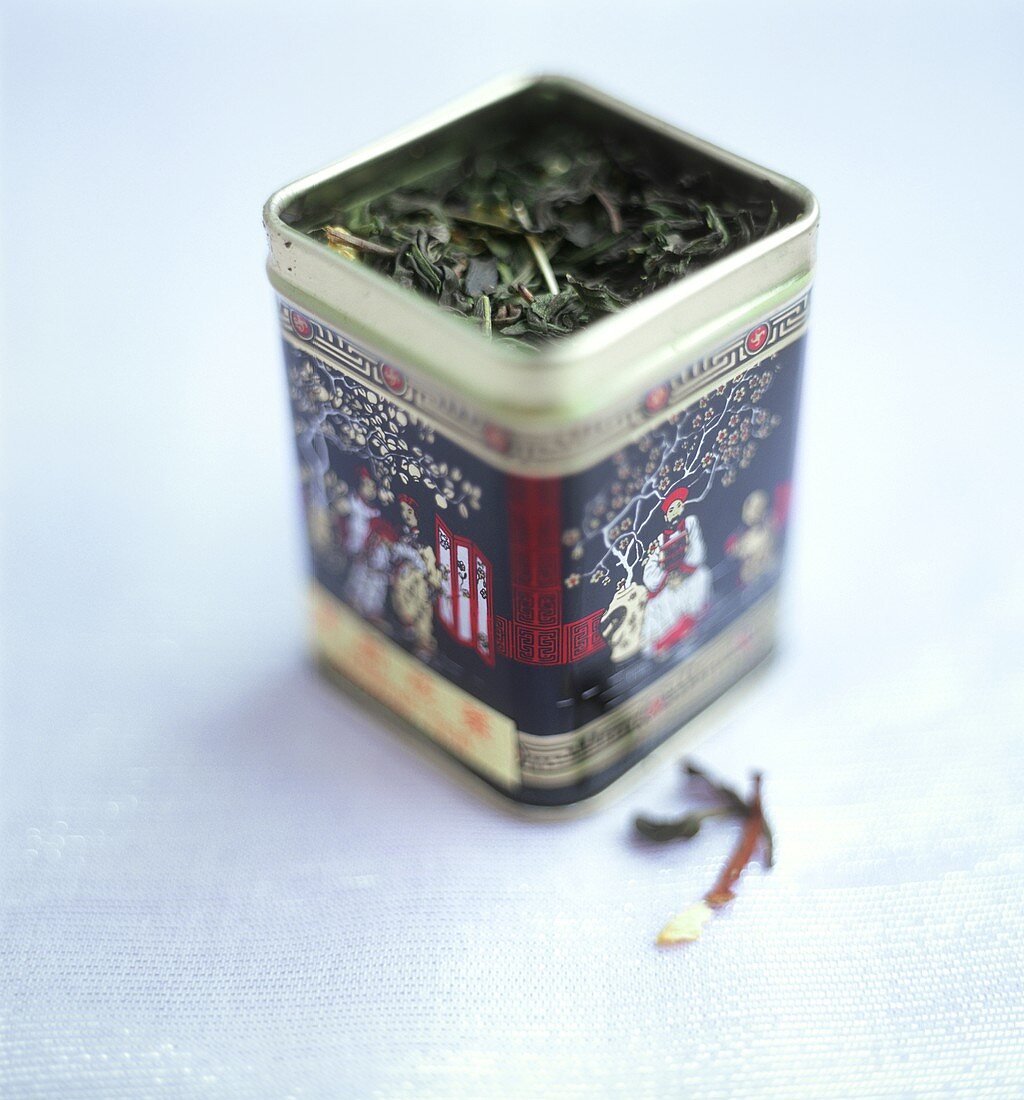 Grüne Teeblätter in asiatischer Teedose