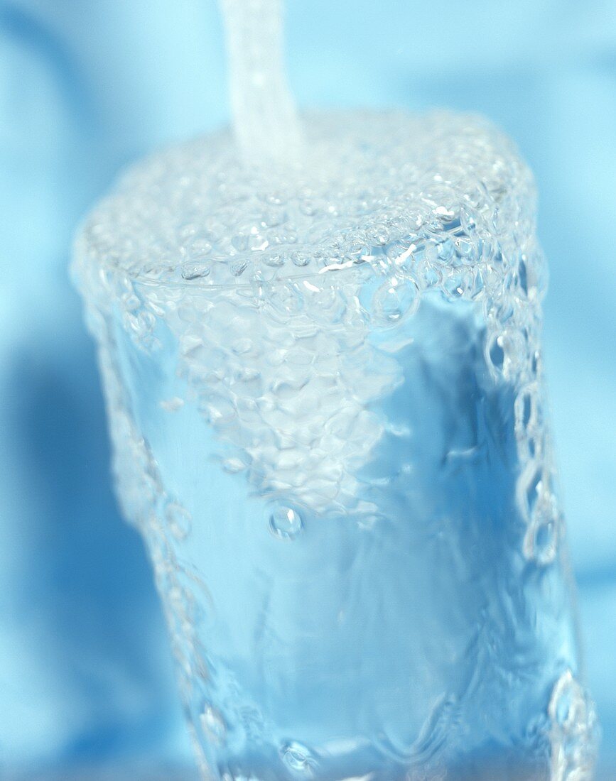 Wasser in Glas füllen