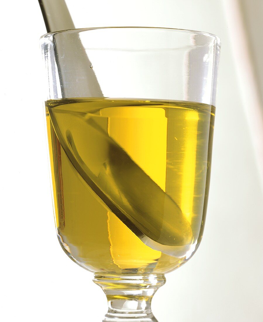 Olivenöl im Glas mit Löffel