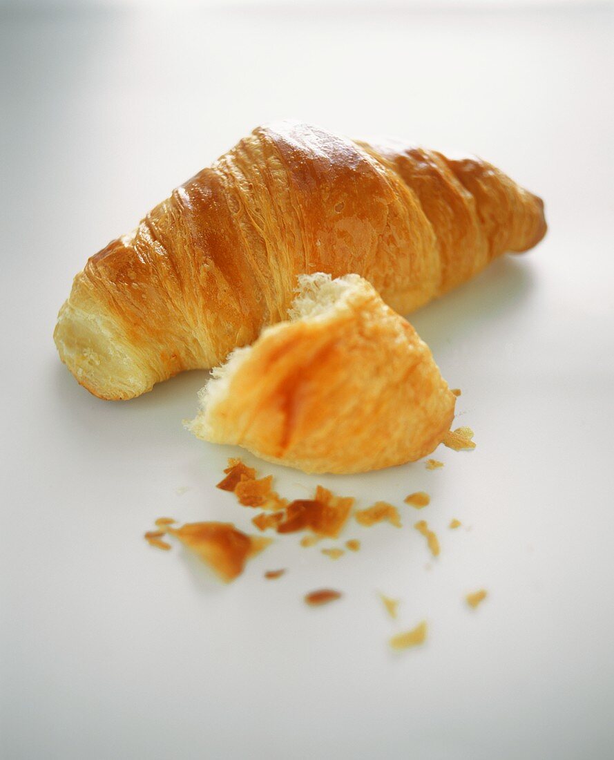 Whole croissant and piece of croissant