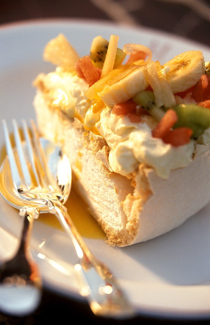 A piece of Pavlova (meringue cake) with fruit and cream