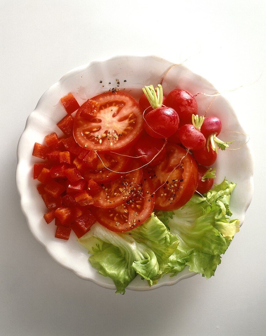 Salad with tomatoes, radishes, peppers and iceberg lettuce