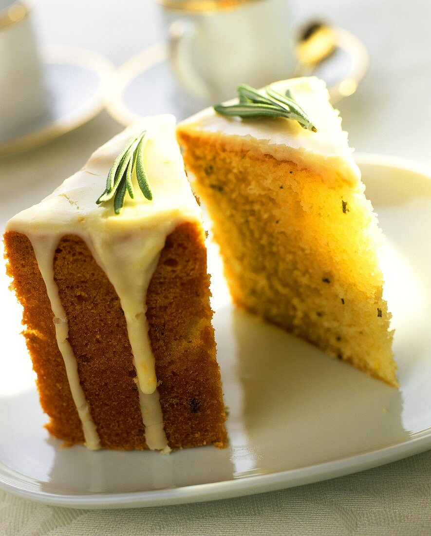 Pieces of Madeira cake with orange icing and rosemary