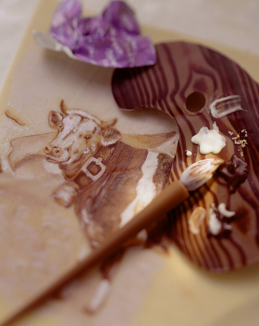 Mit Schokoladenfarbe gemalte Kuh, Schokopinsel und Palette