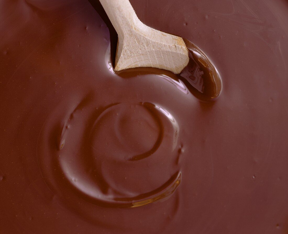 Kochlöffel in geschmolzener Schokolade