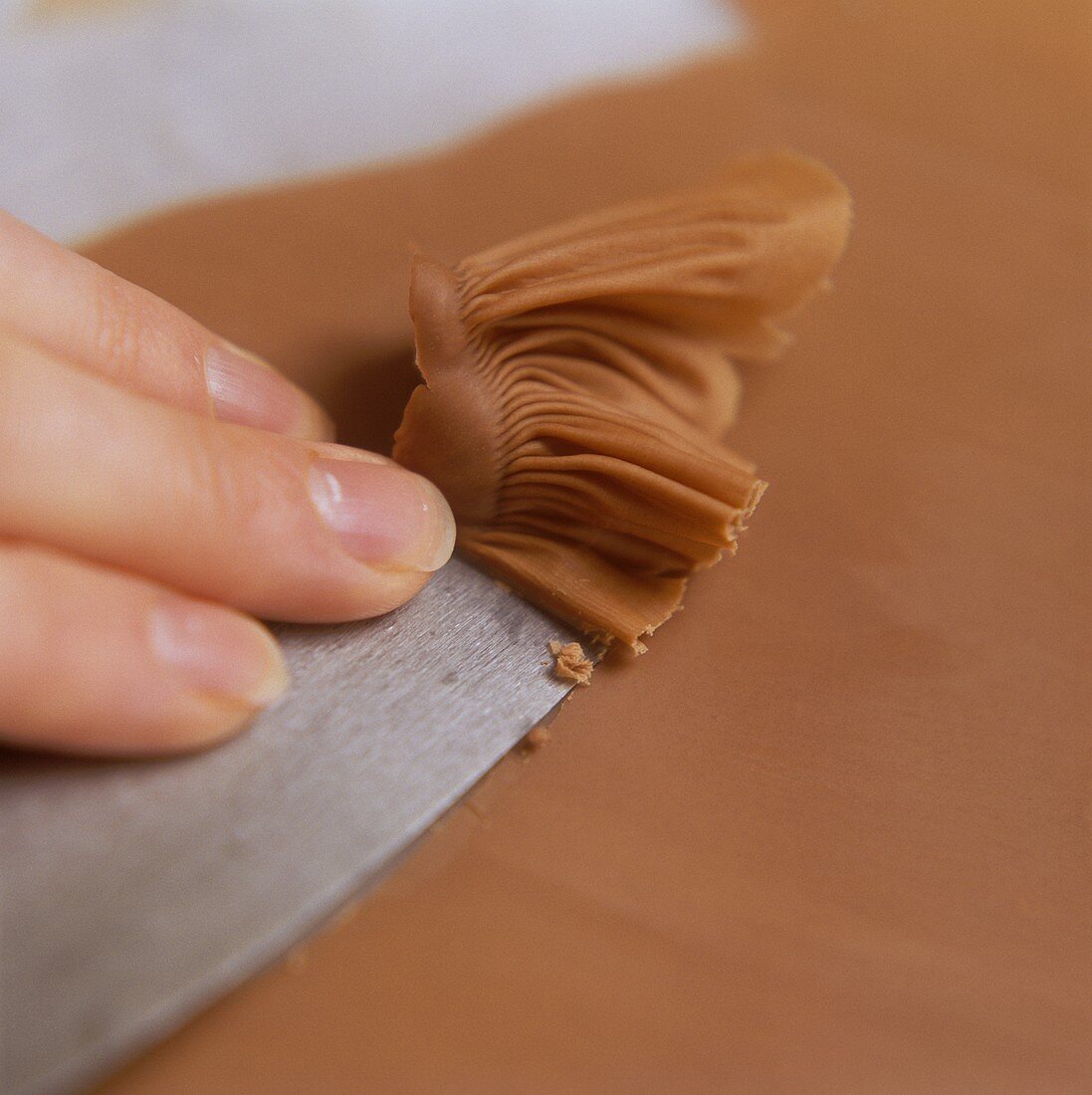 Scraping chocolate from a baking tray (making chocolate fans)