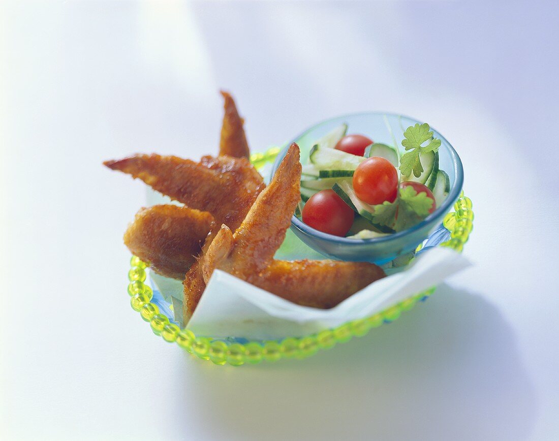 Chicken wings with tomato and cucumber salad