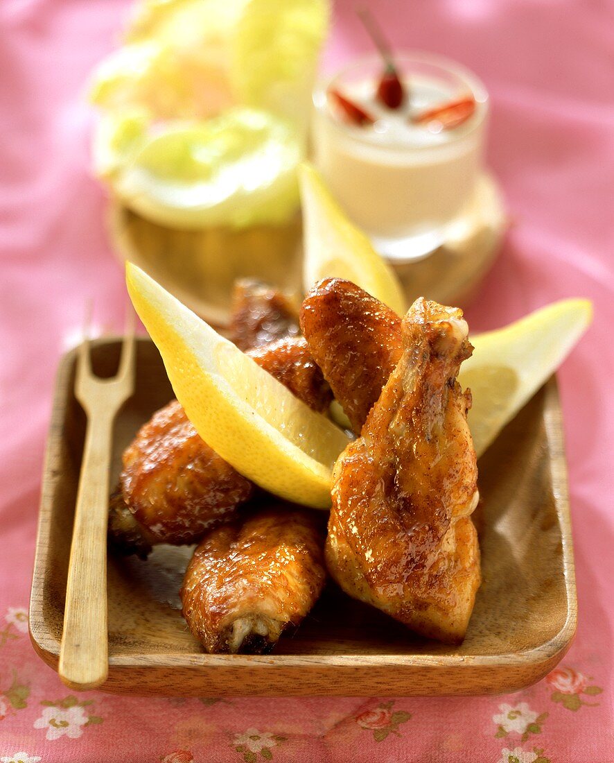Chicken wings with lemon wedges and peanut dip