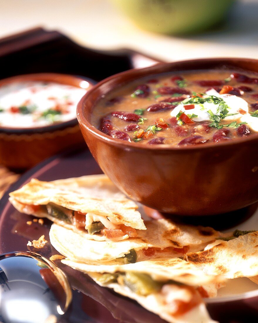 Mexican bean soup with sour cream and quesadillas