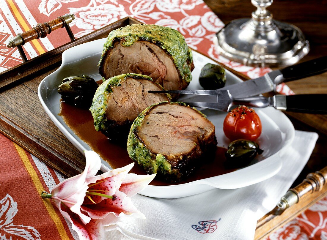 Rolled veal roast with cheese and herb crust (a slice carved)