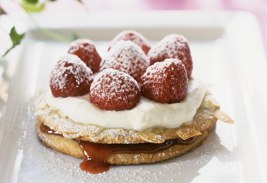 Strawberry almond tartlet with cream and icing sugar