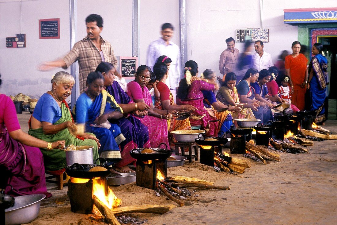 Indische Frauen backen traditionelle Ölkuchen