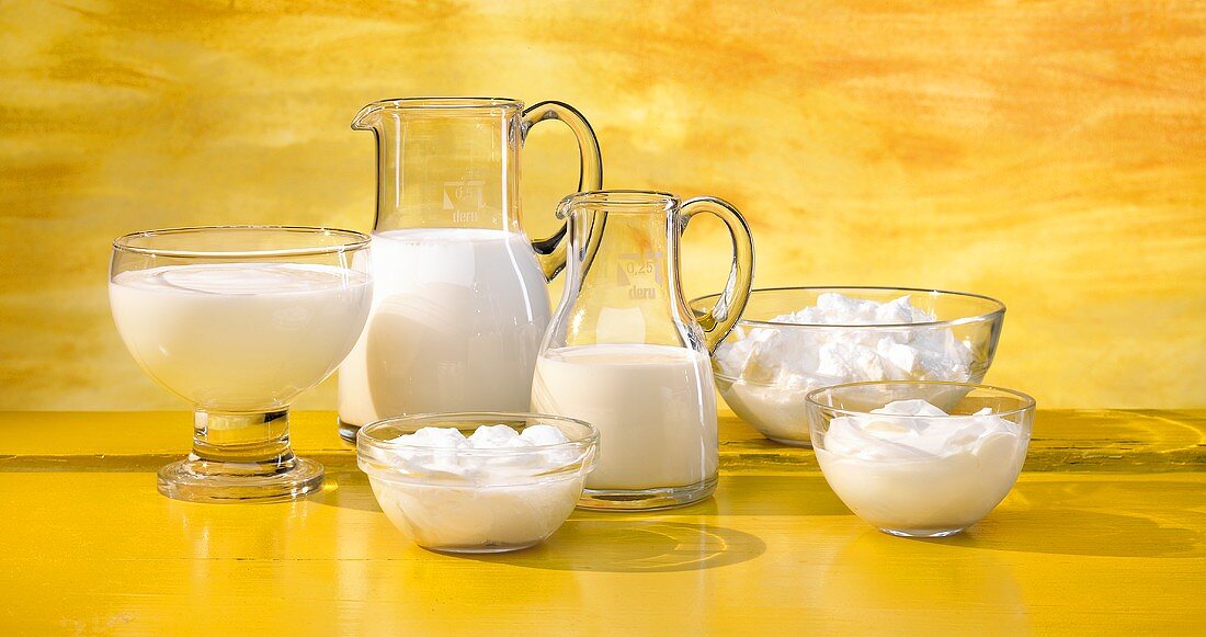 Verschiedene Milchprodukte vor gelbem Hintergrund
