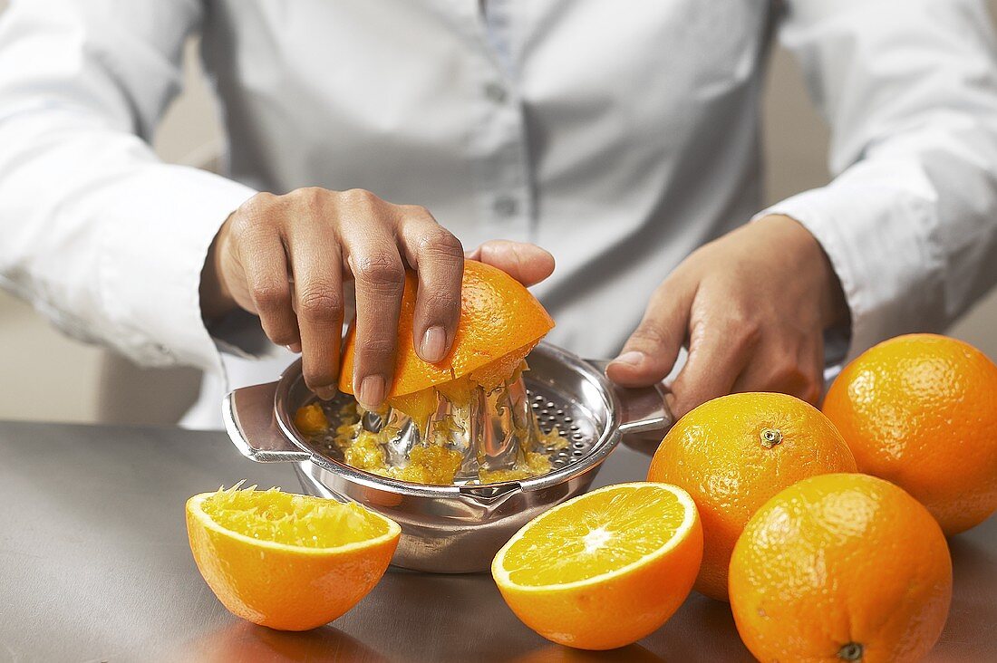 Hands squeezing oranges