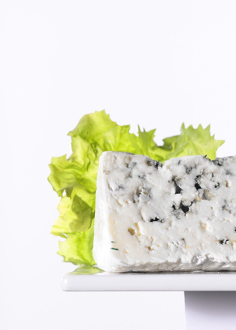 Blue cheese in front of lettuce leaf