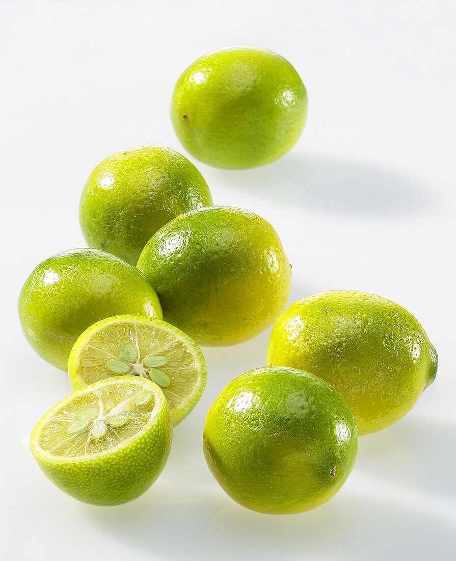 Mehrere Limequats, eine davon halbiert