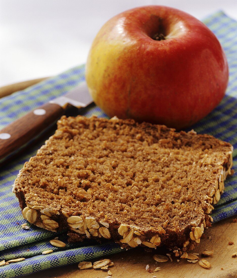 Vollkornbrotscheibe und frischer Apfel