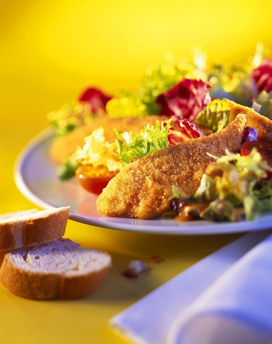 Mixed salad leaves with fried chicken; white bread