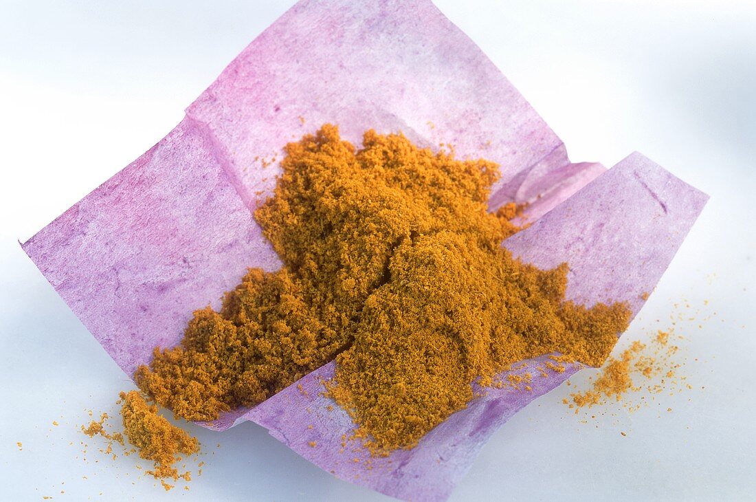 Currypulver auf violettem Papier