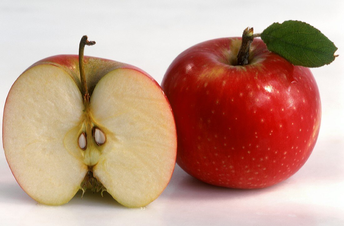 Ganzer und halber roter Apfel (Sorte Pink Lady)