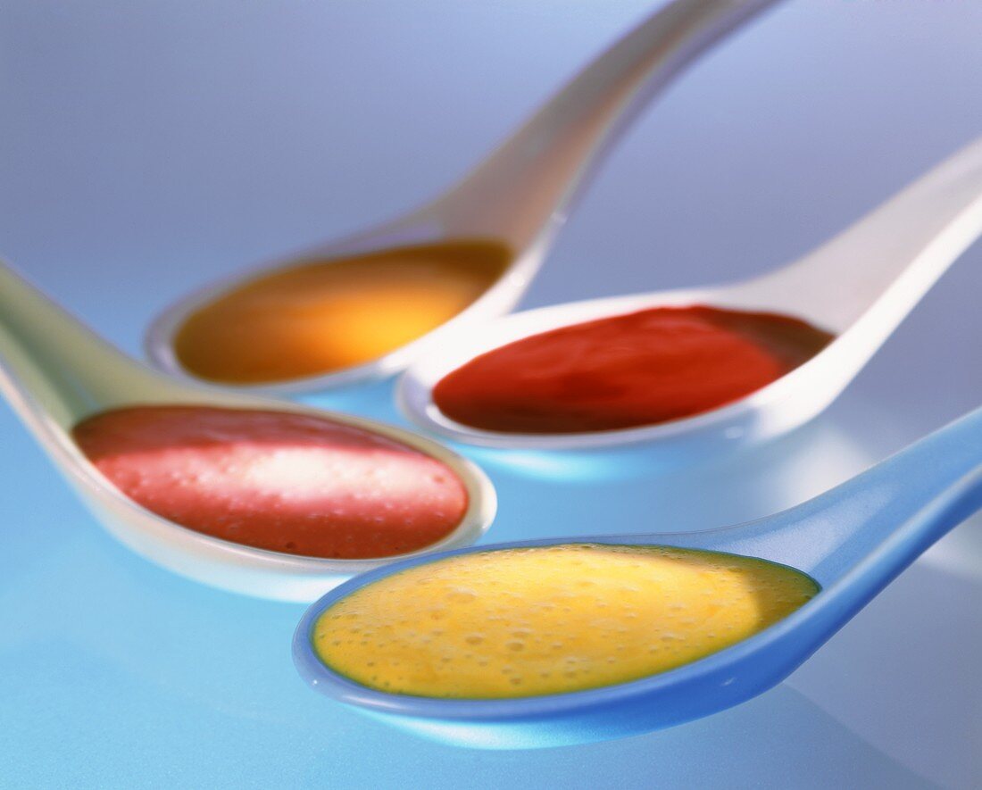 Various fruit sauces in spoons