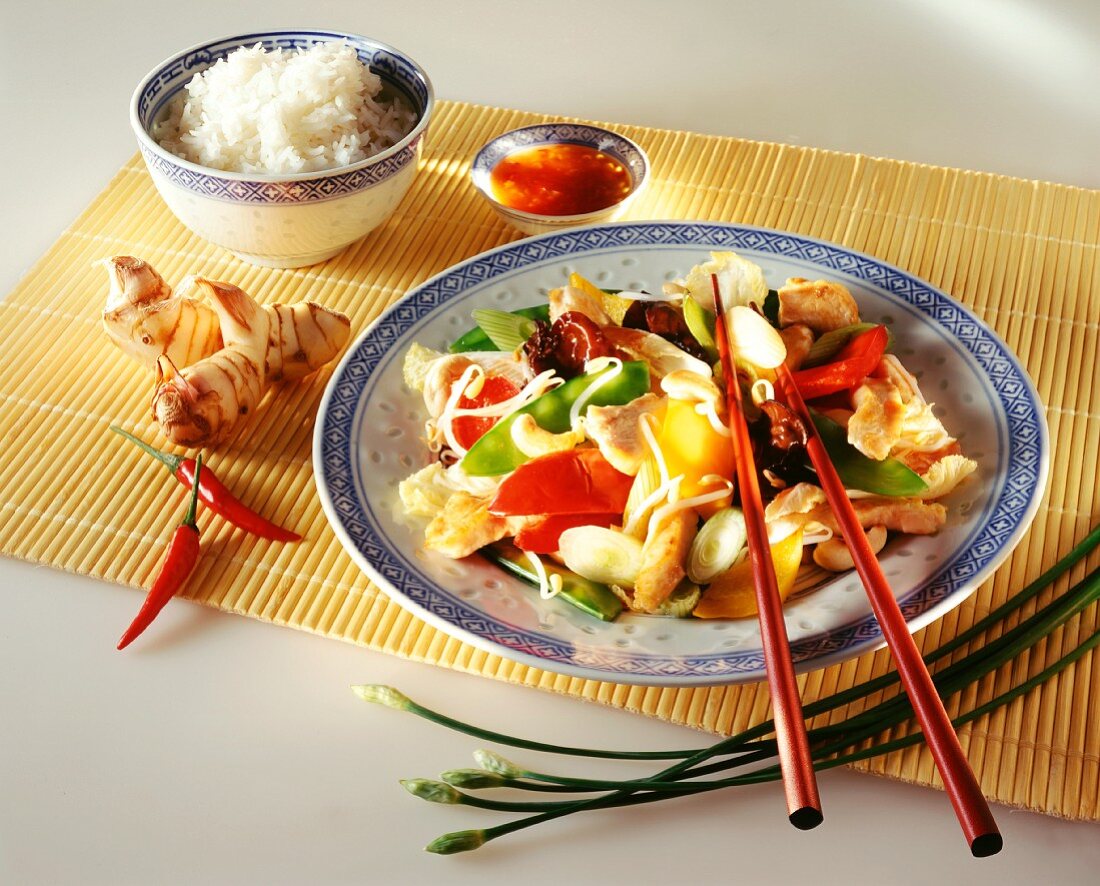 Chicken & vegetables cooked in wok; rice, ginger; chili sauce