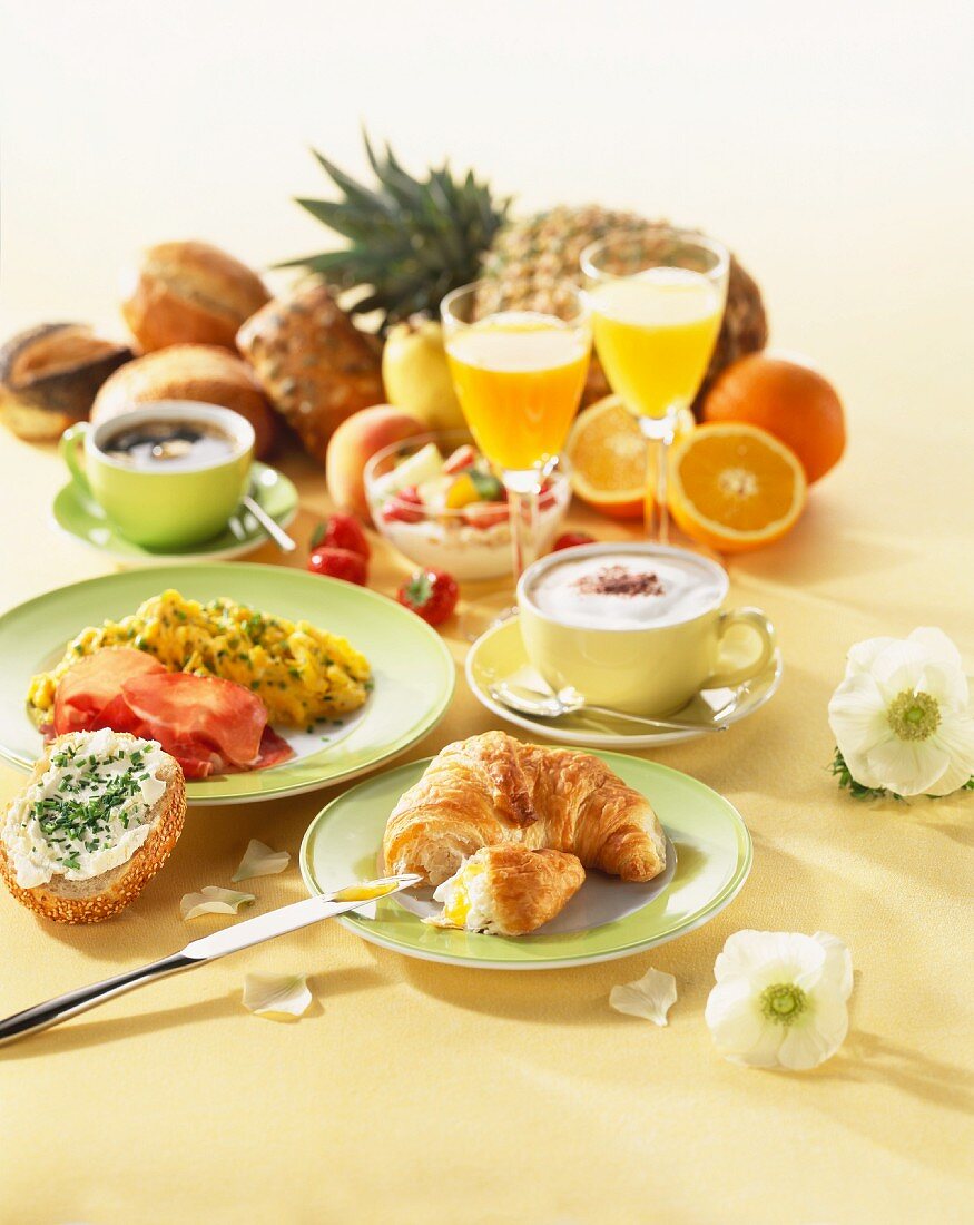 Frühstück mit Croissant, Rührei, Kaffee, Saft und Müsli