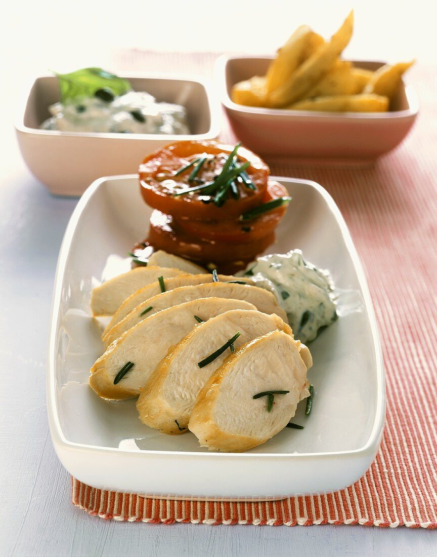 Chicken breast with olive dip, tomatoes and potato wedges