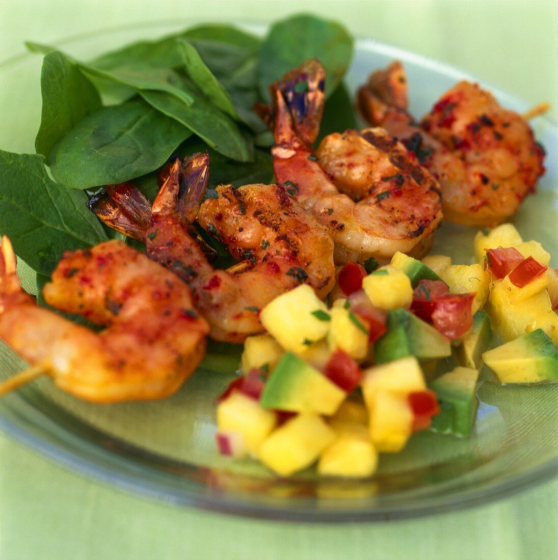 Shrimp kebab with spinach and pineapple and avocado salsa