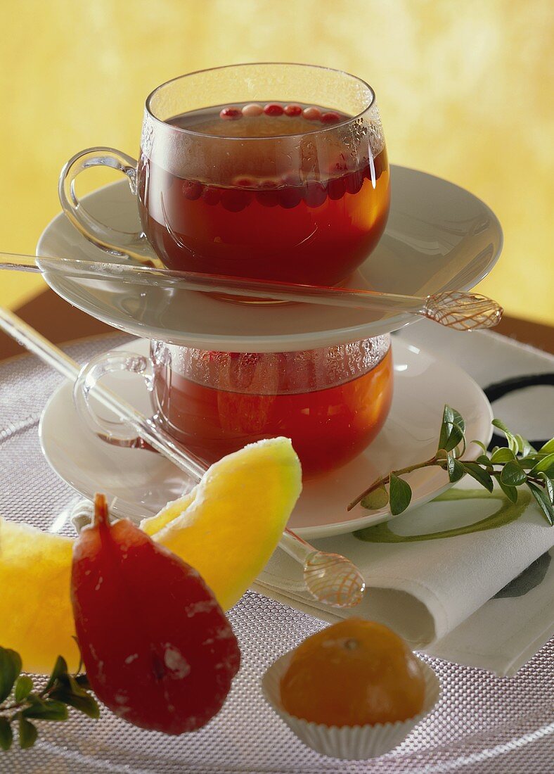Fruit tea with cranberries in glass cups; candied fruit