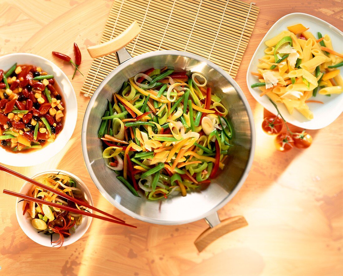 Mixed vegetables in wok among various dishes