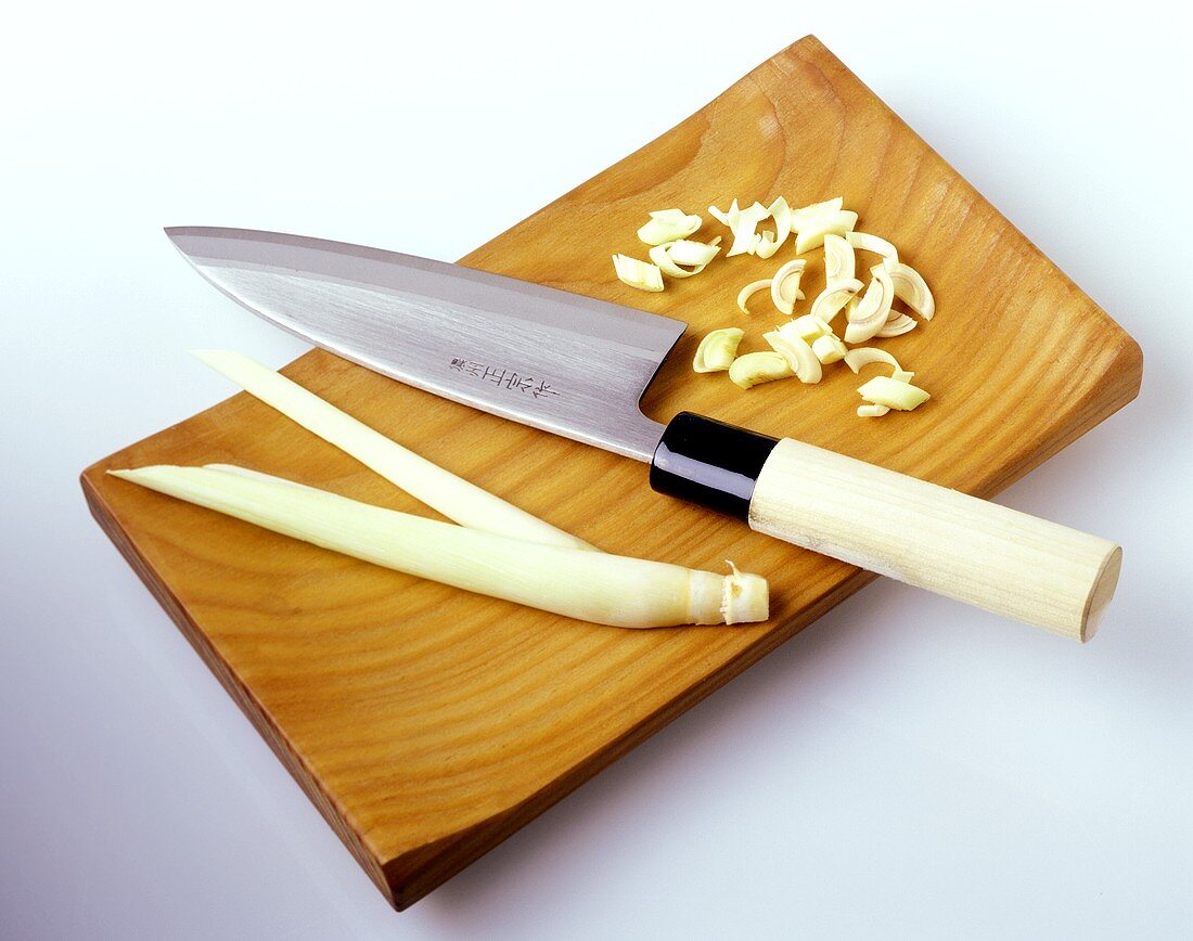 Zitronengras mit asiatischem Messer auf Holzschneidebrett