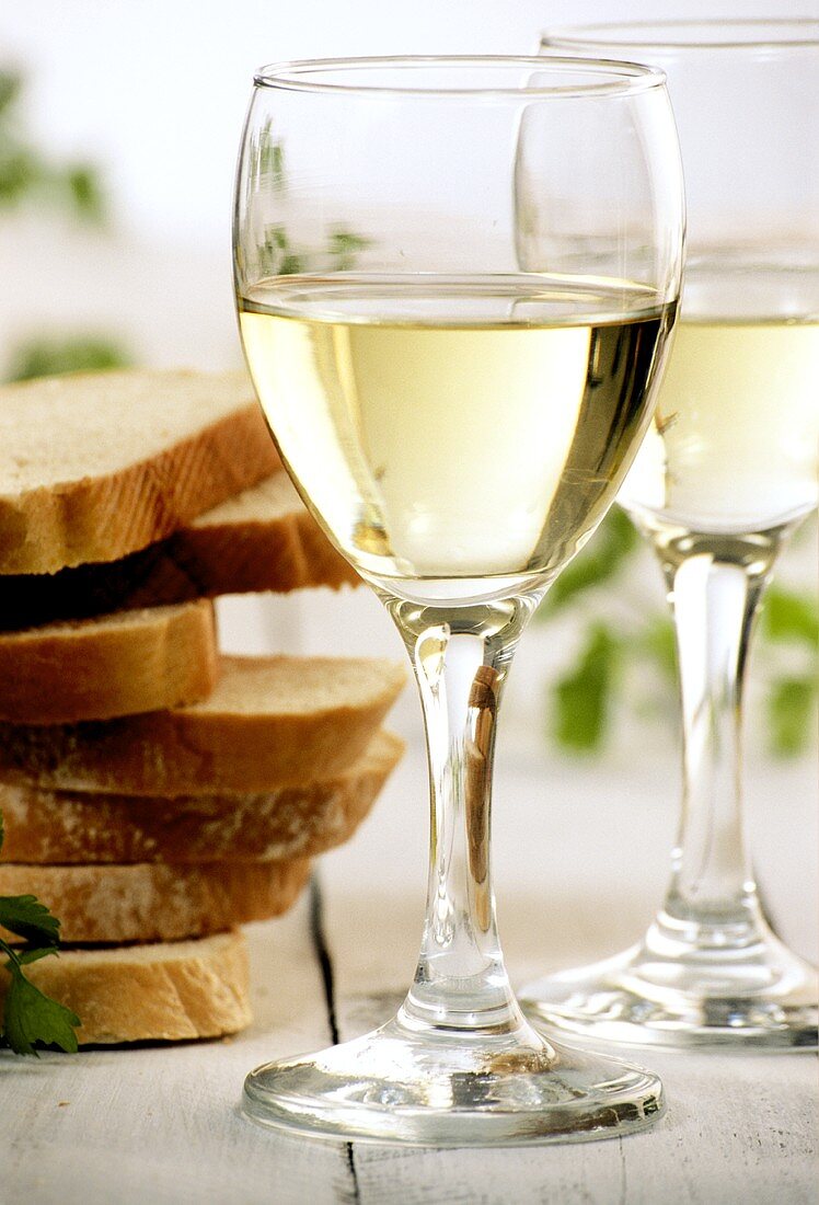 White wine glasses beside slices of white bread
