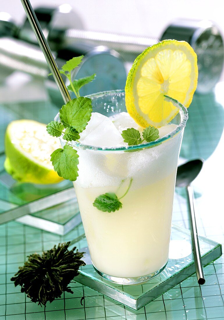 Grüntee-Molke-Drink mit Eiswürfeln, Zitrone und Melisse