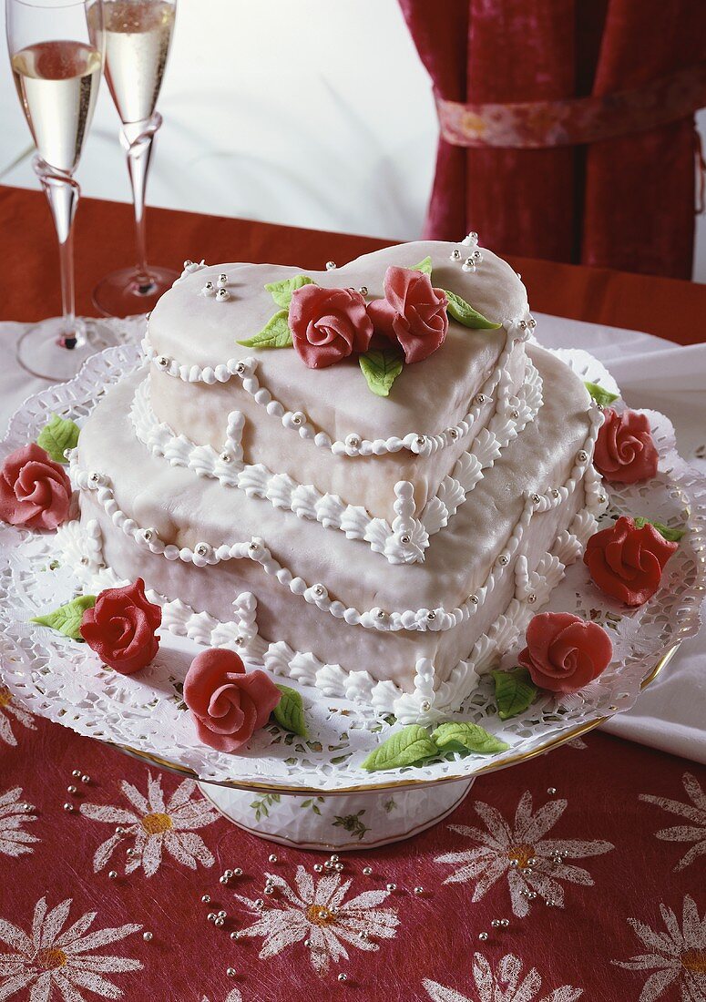 Festive two-tiered heart-shaped cake with marzipan roses