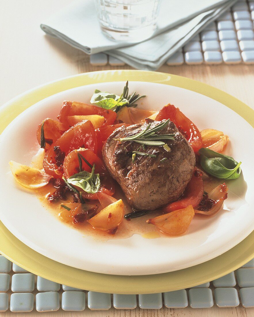 Lamb steaks on tomatoes with rosemary and basil