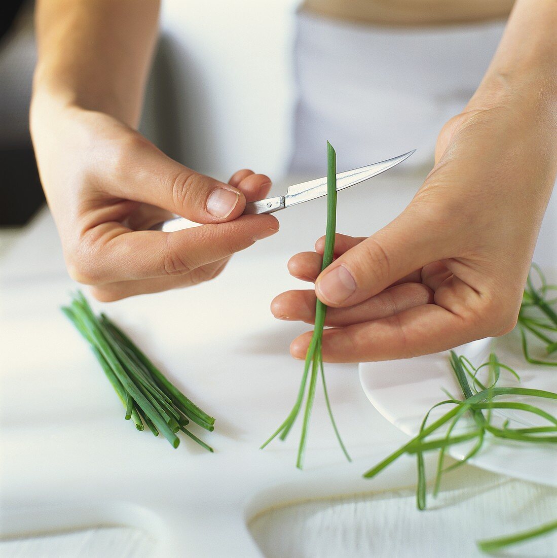 Cutting into chive stalk