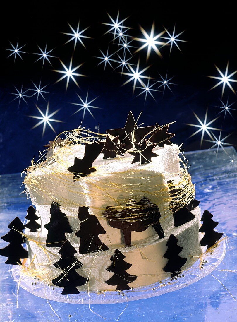 weiße Weihnachtstorte mit Schokoladenfiguren und Zuckerfäden