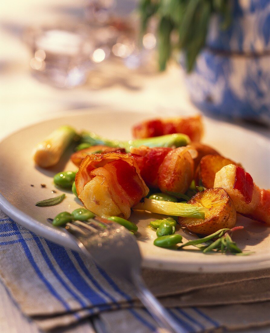 Goat's cheese wrapped in bacon with potatoes and broad beans