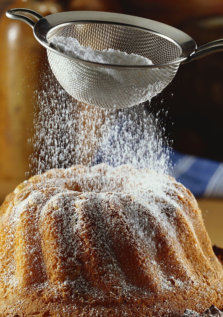 Sprinkling gugelhupf with icing sugar