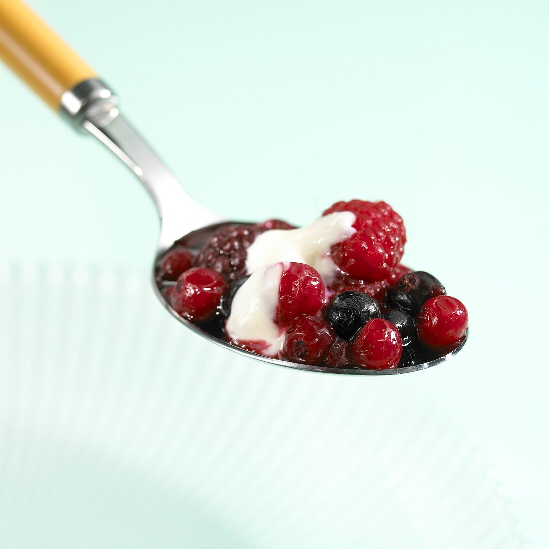 Beeren mit Zimtsahne auf Löffel