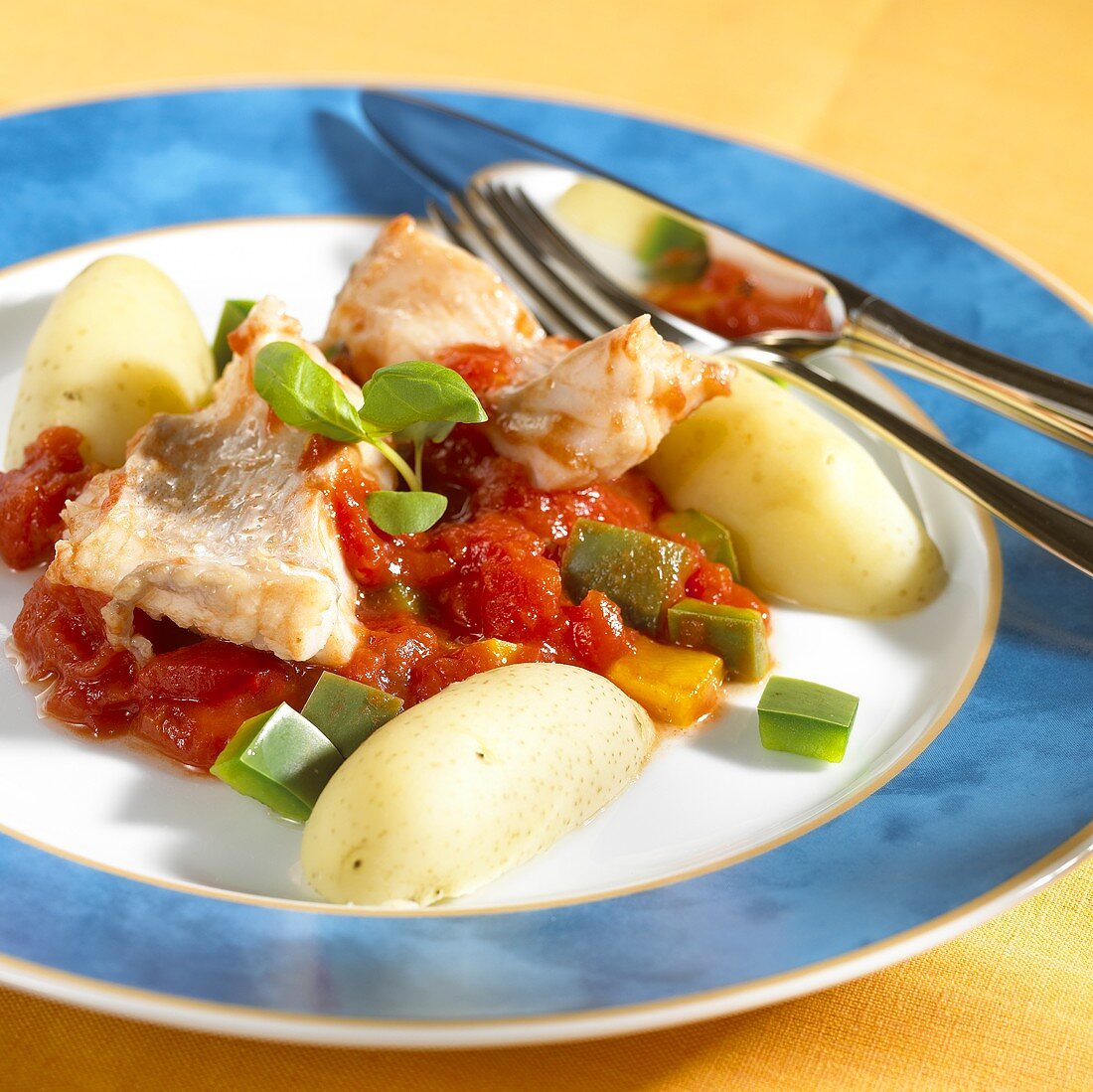 Fish with pepper and tomato sauce and potatoes