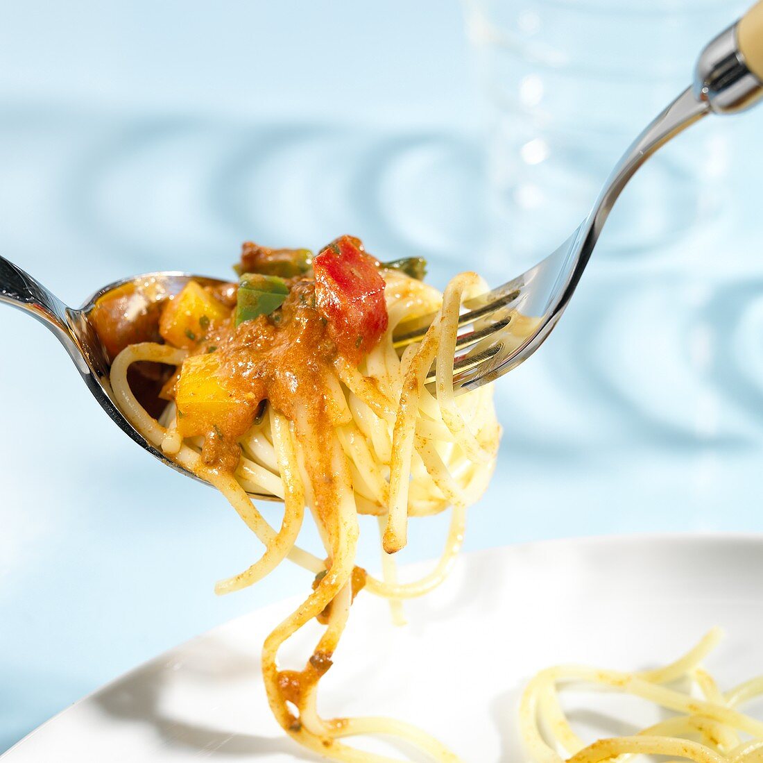 Spaghetti mit Gemüse-Hackfleisch-Ragout auf Gabel und Löffel