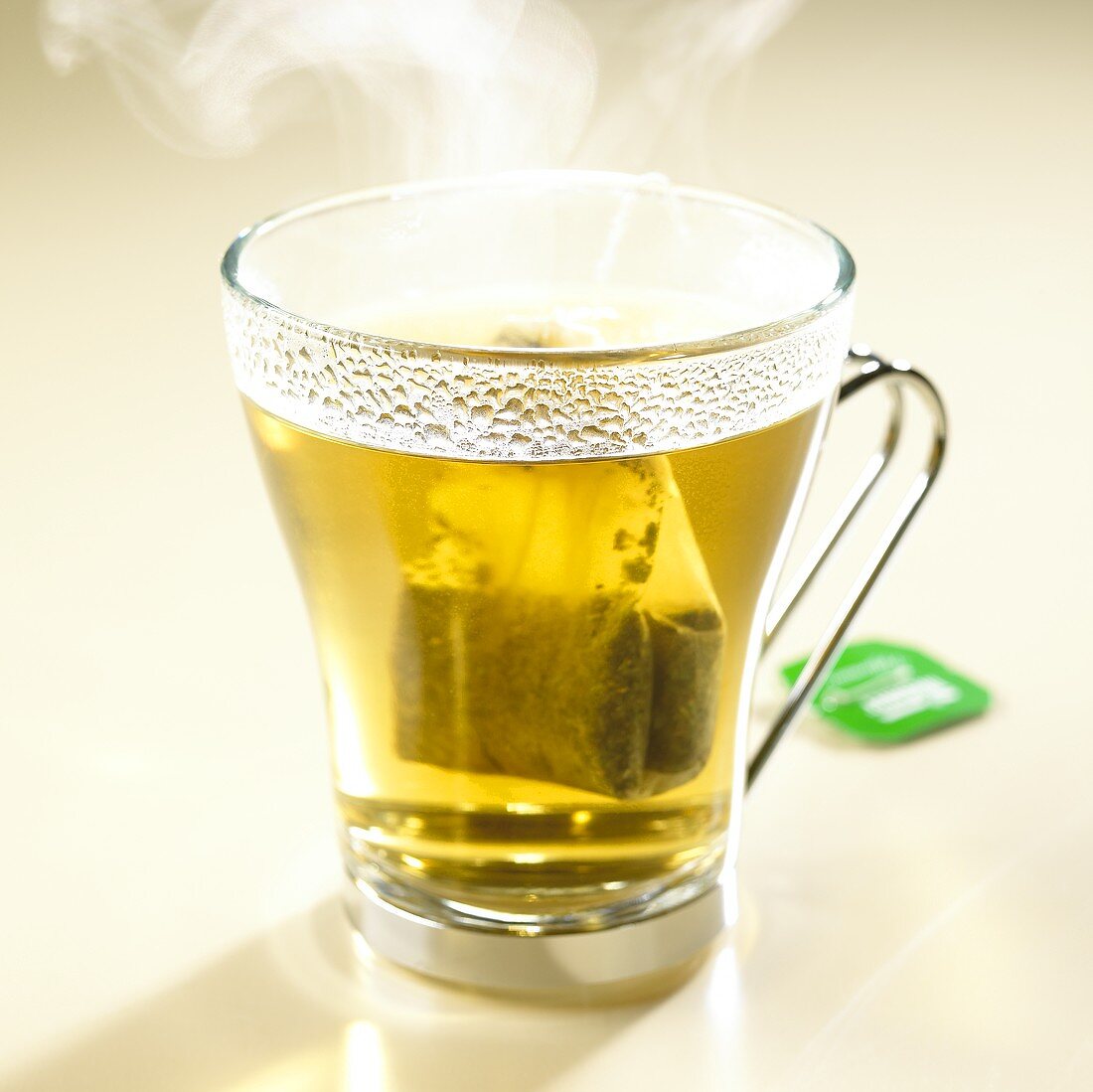 Steaming peppermint tea with tea bag in glass