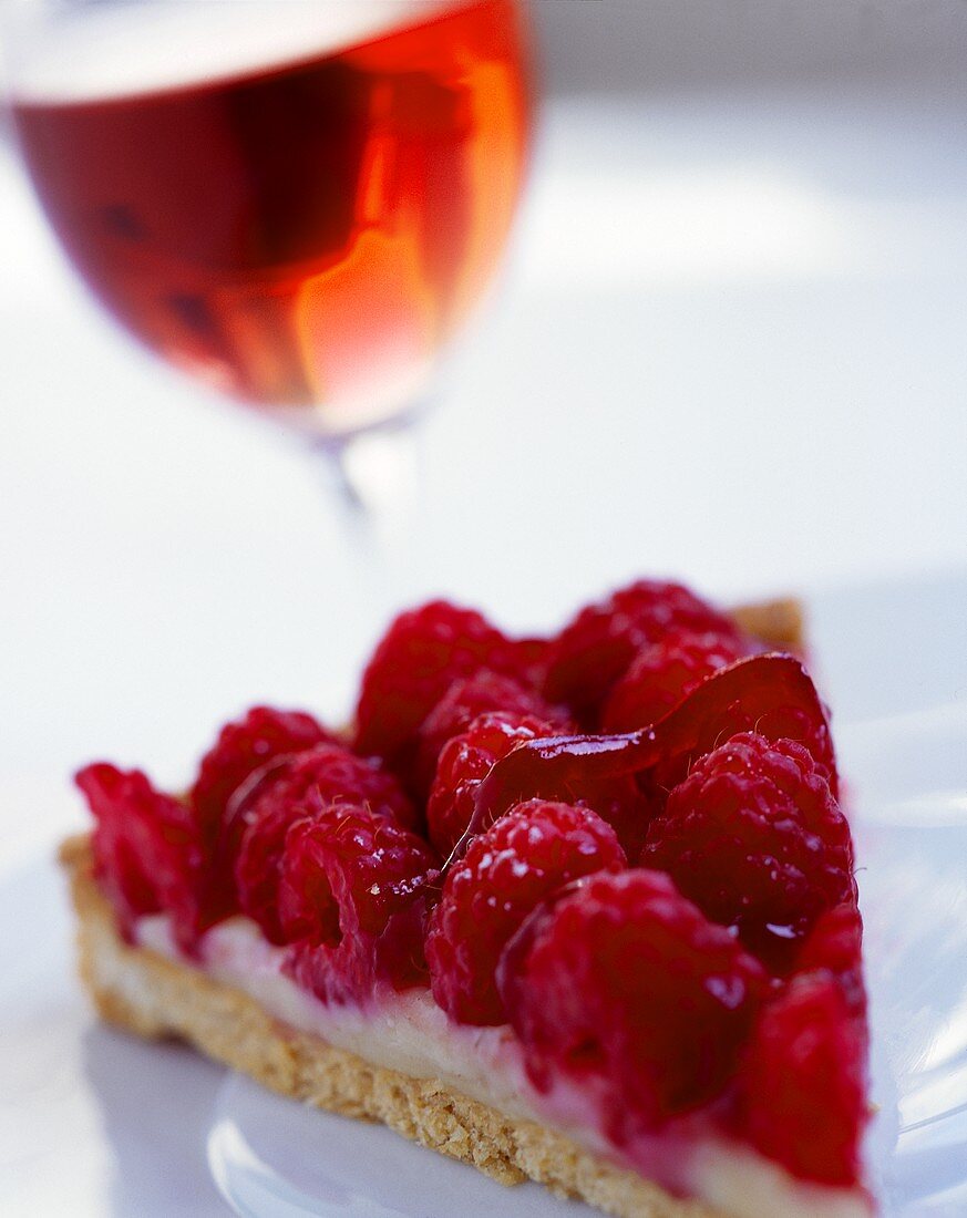 Piece of raspberry flan and glass of rosé wine