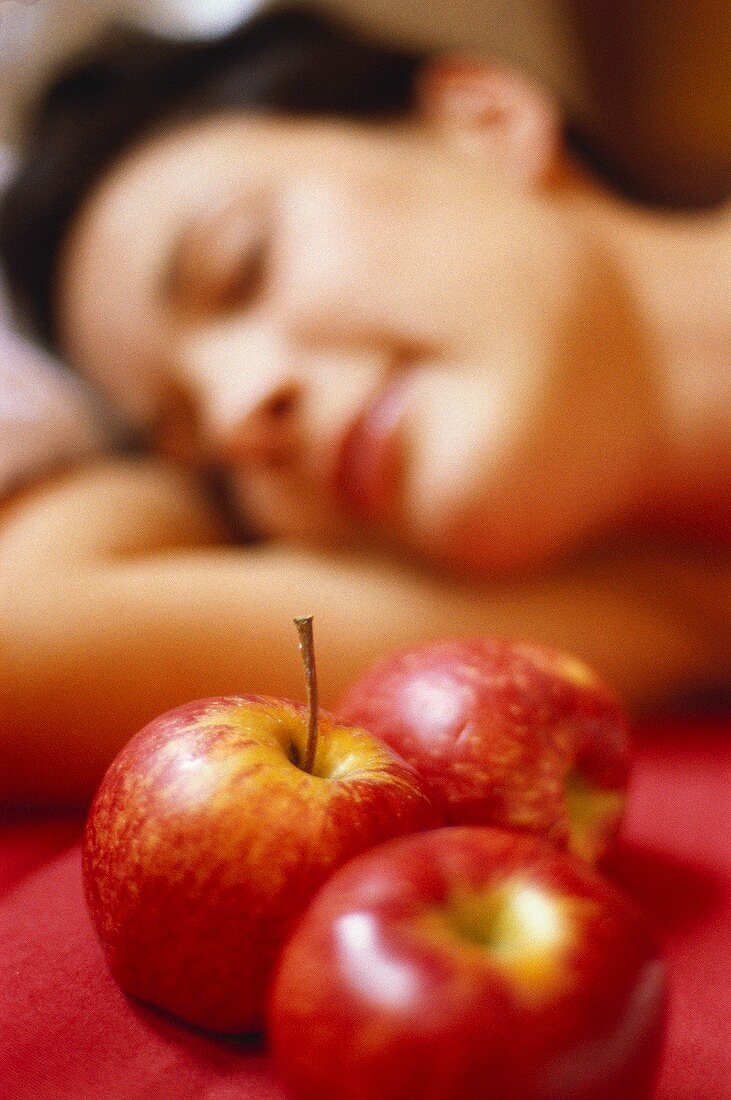 Red apples in front of woman's face