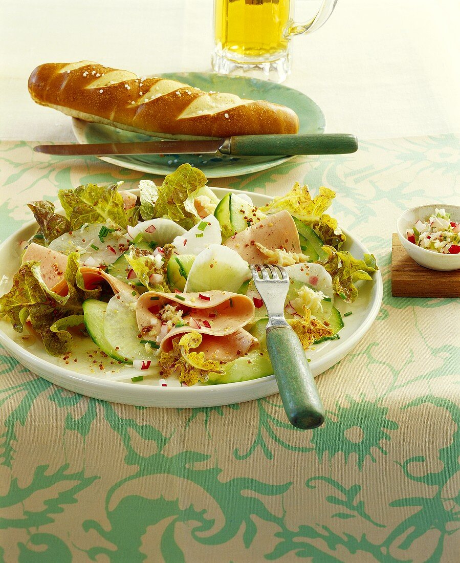 Sausage salad with radish and cucumber; pretzels; beer