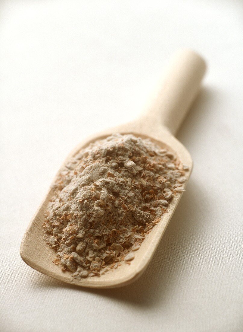 Coarsely ground wheat on small wooden scoop