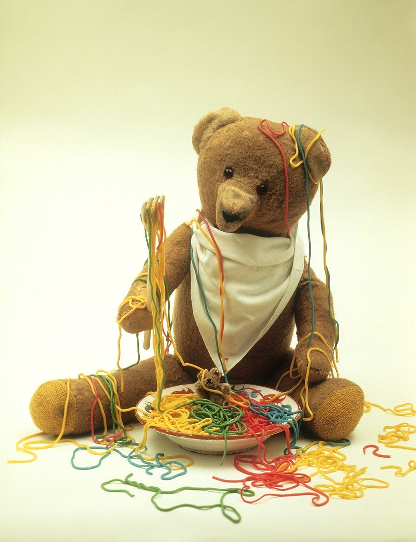 Teddybär mit bunten Spaghetti